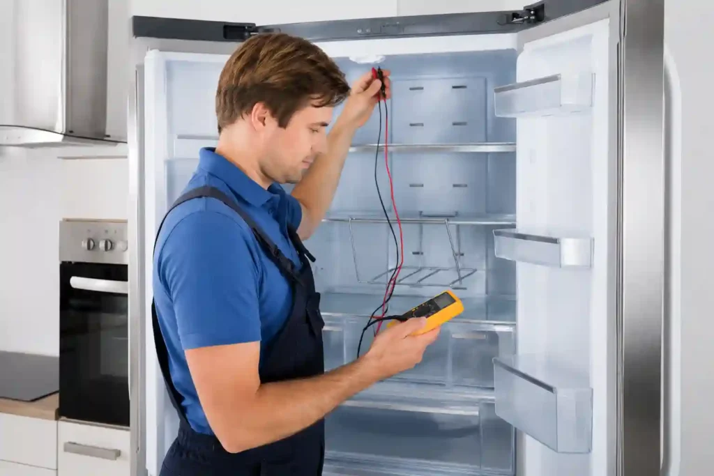 Technician testing refrigerator wires and electrical components with a multimeter.