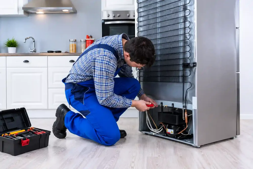 Technician servicing refrigerator compressor.