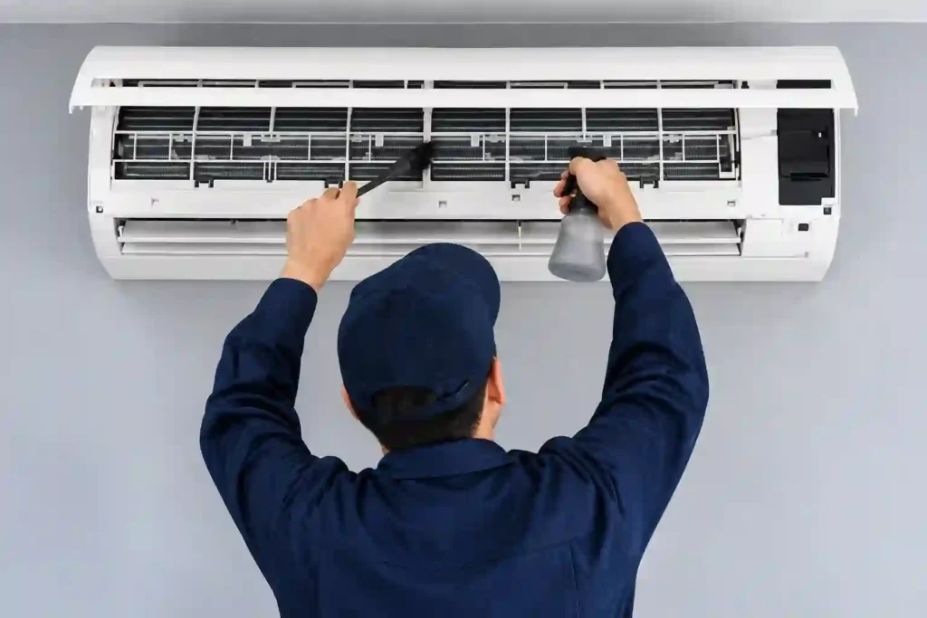 Technician servicing a split AC indoor unit.