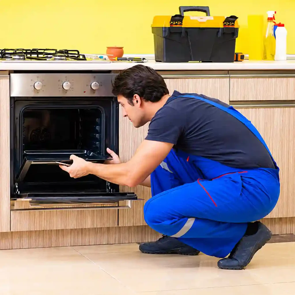 Technician performing maintenance on a kitchen oven.
